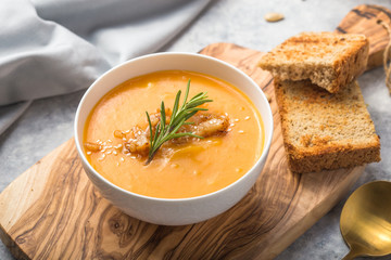 Homemade Autumn Butternut Squash pumpkin cream Soup with Bread and seeds. top view