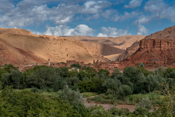Moroccan berber village with mountains, river, desert, mountains and lush vegetation