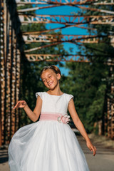 Fototapeta premium Portrait of cute little girl on white dress and wreath on first