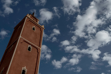 Moroccan square minaret taken from below with beautiful blue sky and clouds