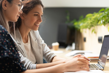 Caucasian and vietnamese ethnicity women colleagues working together at workplace