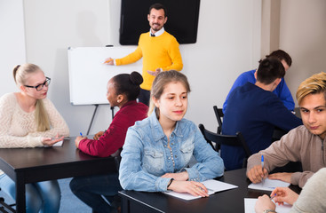 Young female and male students are working in large groups