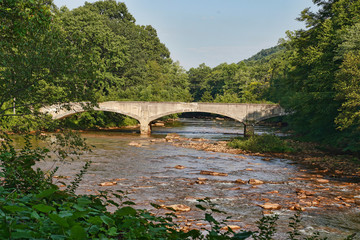Fototapeta na wymiar Arched, old, bridge along the rail to trails in Western Pennsylvania.