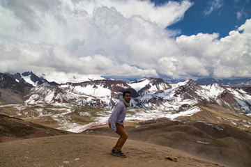 Fototapeta premium Man with panoramic view. Hiking scene in Vinicunca, Cusco region, Peru. Montana of Seven Colors, Rainbow Mountain