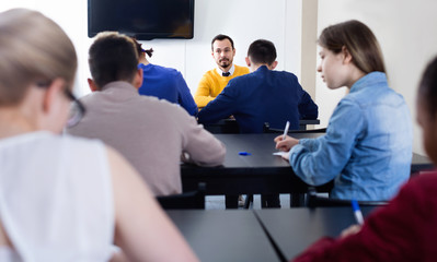 Teacher monitoring students’ work during examination test in class © JackF