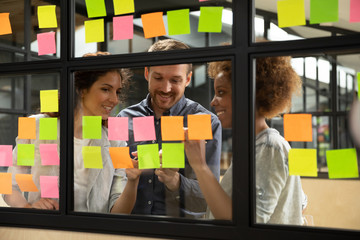 Affiliates using colourful sticky notes writing brief information planning work