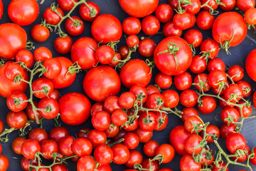 Raw tomatoes on black background.
