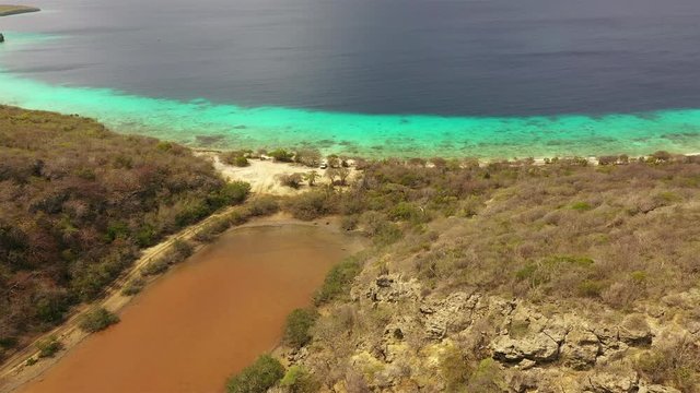 Aerial view of coast of Curaçao in the Caribbean Sea with turquoise water, cliff, beach and beautiful coral reef around Playa Largu