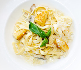 pasta with mushrooms and cream sauce in a white plate