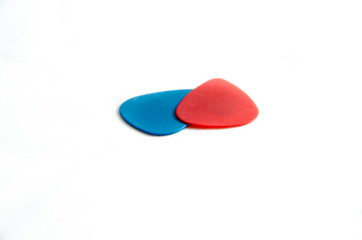 Red and blue guitar pick for guitar. Plectrum for playing stringed instruments. Macro. On white background