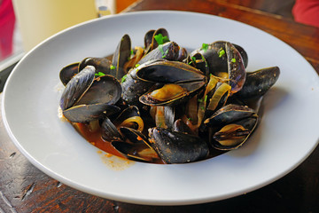 Plate of mussels in the shell cooked in tomato sauce