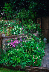 Fototapeta na wymiar 'The Old Gate' farmyard garden with natural planted flower border