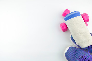 Fitness concept background with sneakers, dumbbells and towel. Top view with space for your text.