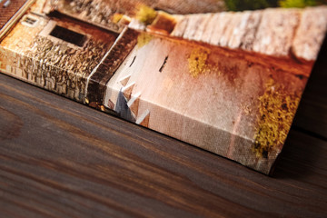 Canvas photo print on brown wooden background. Side view of colorful photography with gallery wrap....