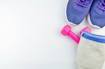 Fitness concept background with sneakers, dumbbells and towel. Top view with space for your text.