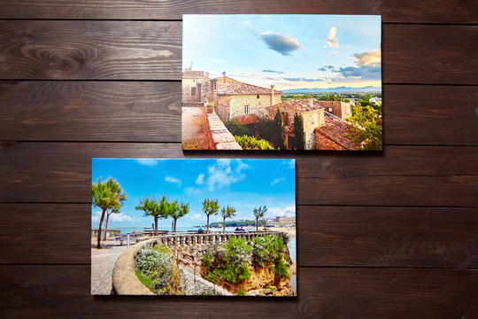 Canvas photo prints on brown wooden background. Front view of colorful photographs printed on glossy synthetic canvas. Photos hanging on a wall