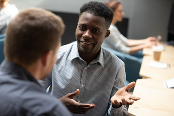 African office worker share thoughts and skills to caucasian colleague