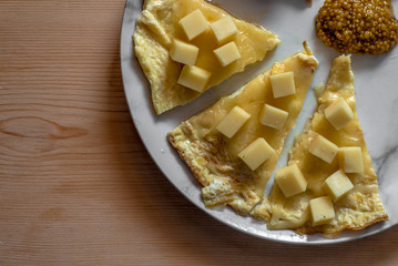 omelet with bacon, cheese cubes and mustard seeds