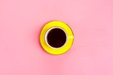 yellow cup with plate and hot coffee americano with steam isolated on pink background Flat lay Top view
