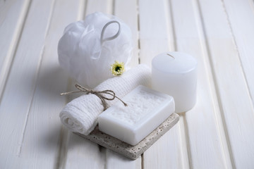 Handmade soap with a pattern lies on the table.  On a white table is handmade soap, a towel and a washcloth.  Collection of items for the bathroom
