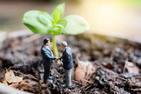 Miniature figures with planting tree ,Environment and business concept