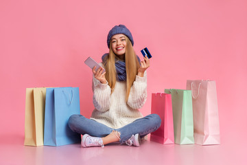 Pretty girl using phone and credit card for online shopping