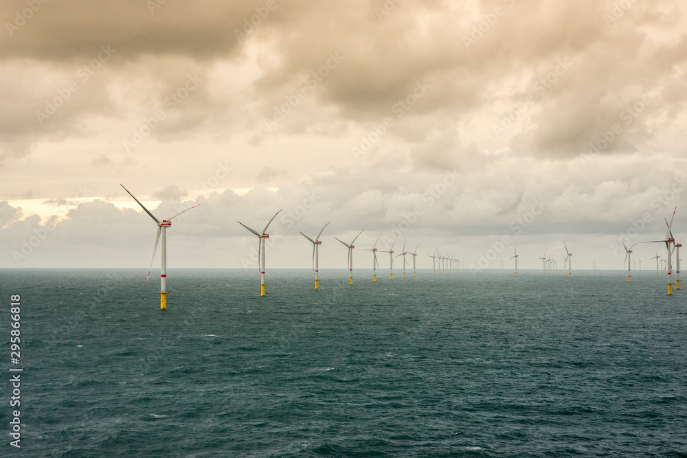 Wall mural sunset over offshore wind farm - green power generation