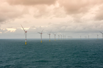 Sunset over offshore wind farm - green power generation	
