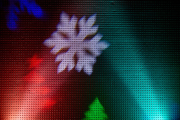 Blue and red rays of light on a black background.  Colored snowflakes and christmas trees