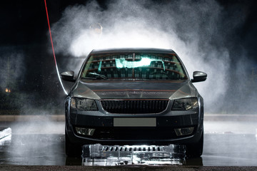 Obraz premium Car close-up. Car wash. Manual car wash with pressurized water in car wash outside. 