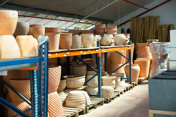 Clay pots and flower vases on racks in store