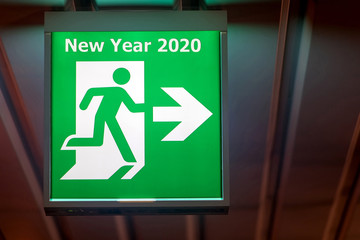 The emergency exit sign shows the direction of escape for happy New Year. The board pointing way to...
