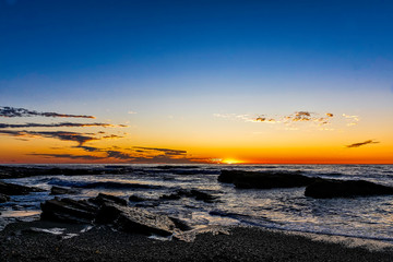 Obraz premium Rocky Shoreline at Sunset over Ocean