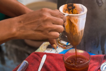 Making traditional Thai milk tea using coffee bag in Stainless Steel Pot. Old Thai tea made shop street food.
