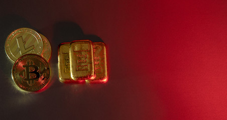 Gold bars and cryptocurrency coins on a red background. Current trends in financial markets.