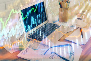 Financial graph colorful drawing and table with computer on background. Double exposure. Concept of international markets.