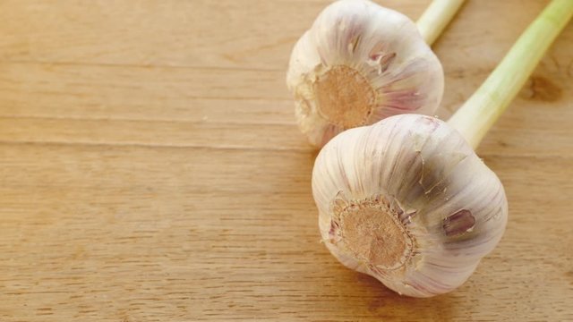 Two garlic bulbs on wooden rustic board. Healthy food. Place for text, copy space