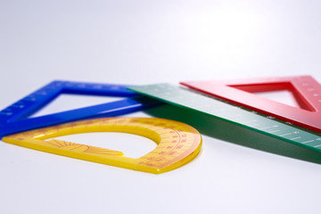 Close up of colourful rulers and protractor in white background