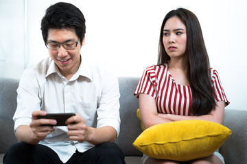 The girl looked at her boyfriend in anger because he kept playing his mobile phone until ignoring the relationship of the surrounding.