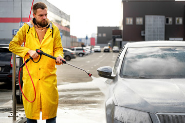 Car close-up. Car wash. Manual car wash with pressurized water in car wash outside. 