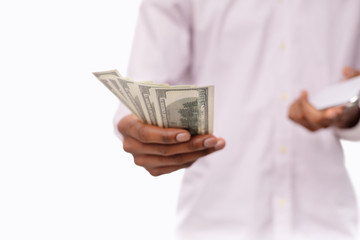 Unrecognizable black man holding bunch of dollars and smartphone