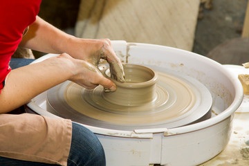 Potière en tournage d'une poterie en argile