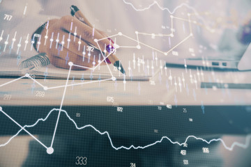 Double exposure of woman's hands making notes with forex graph hologram. Concept technical analysis.