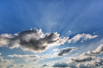 Fototapeta na wymiar Blue cloudy sky with sun rays