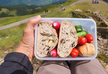 man holding Brotzeit box, lunch in the mountains