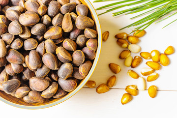 Cedar cone, nuts and a branch of Siberian cedar on a light wooden background. The concept of...