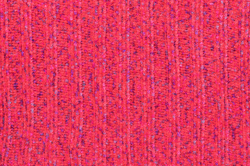 Background in the form of knitted material from red wool with vertical stripes and blue spots