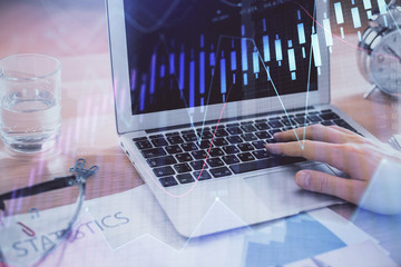 Multi exposure of market chart with man working on computer on background. Concept of financial...