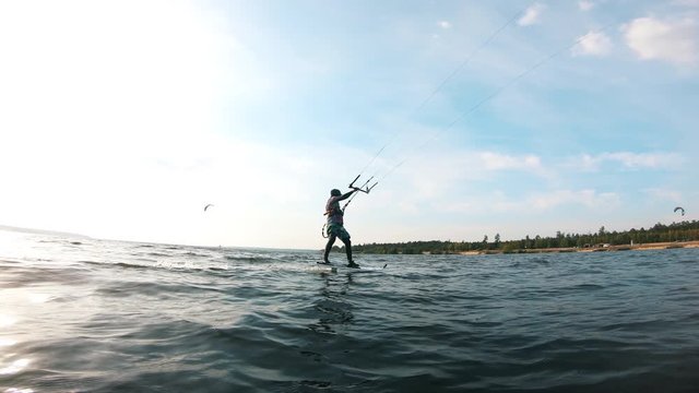 Male athlete kite surfing on river.