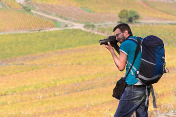 un homme photographie des vignes en automne &agrave; Beaune